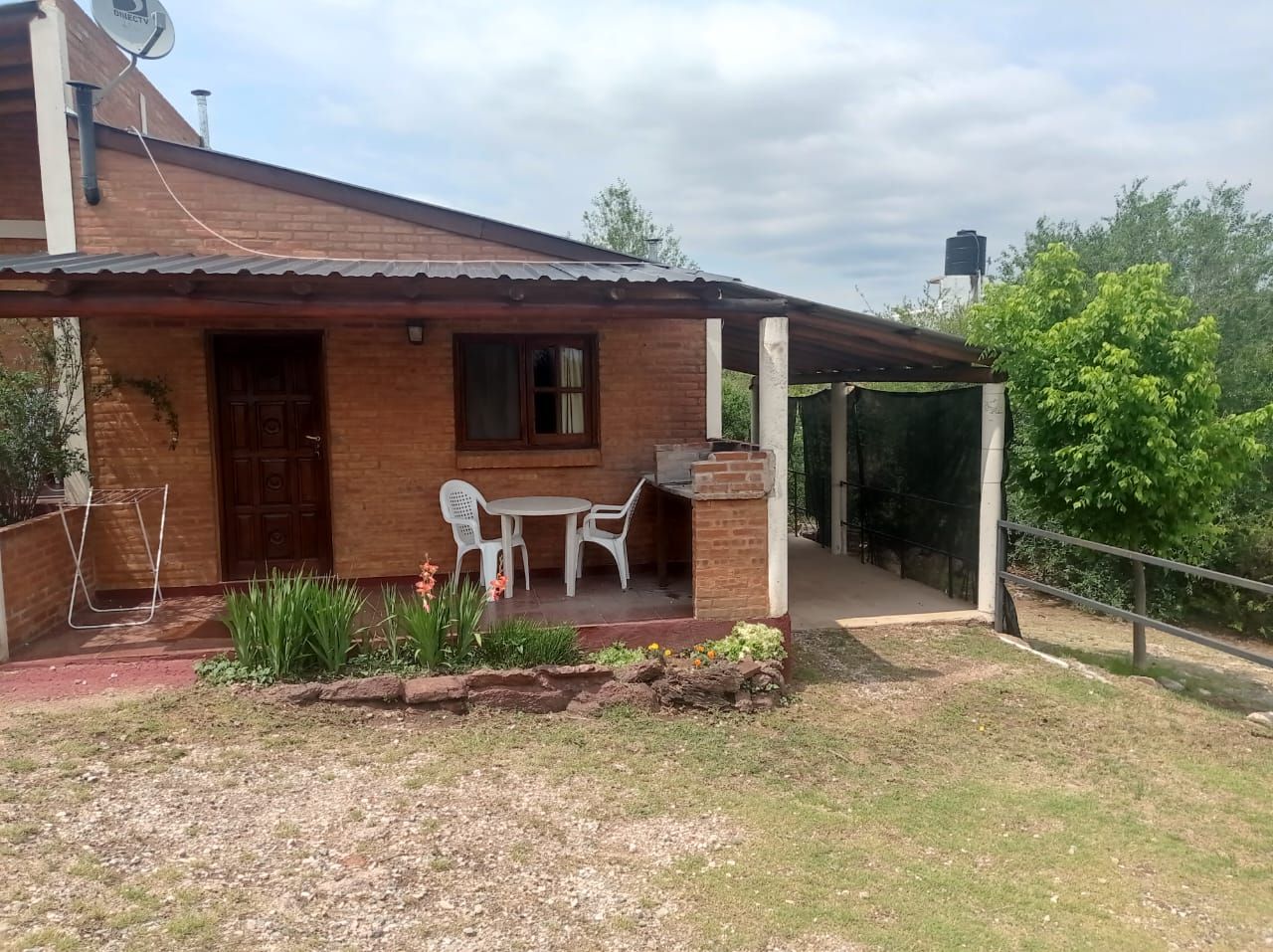 Cabaña de ladrillo con galería y parrilla