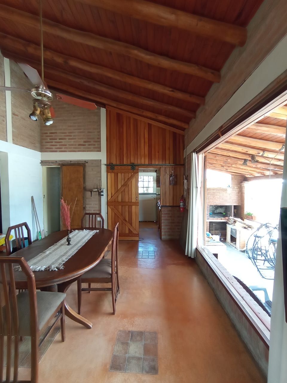 Comedor de la casa con ventanal hacia el quincho