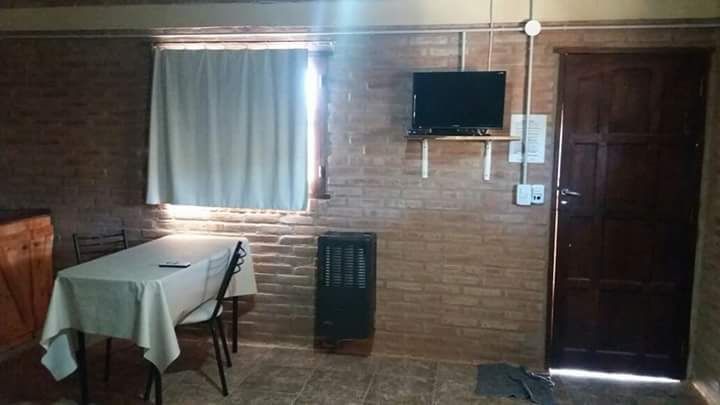 Interior de un monoambiente con TV y mesa