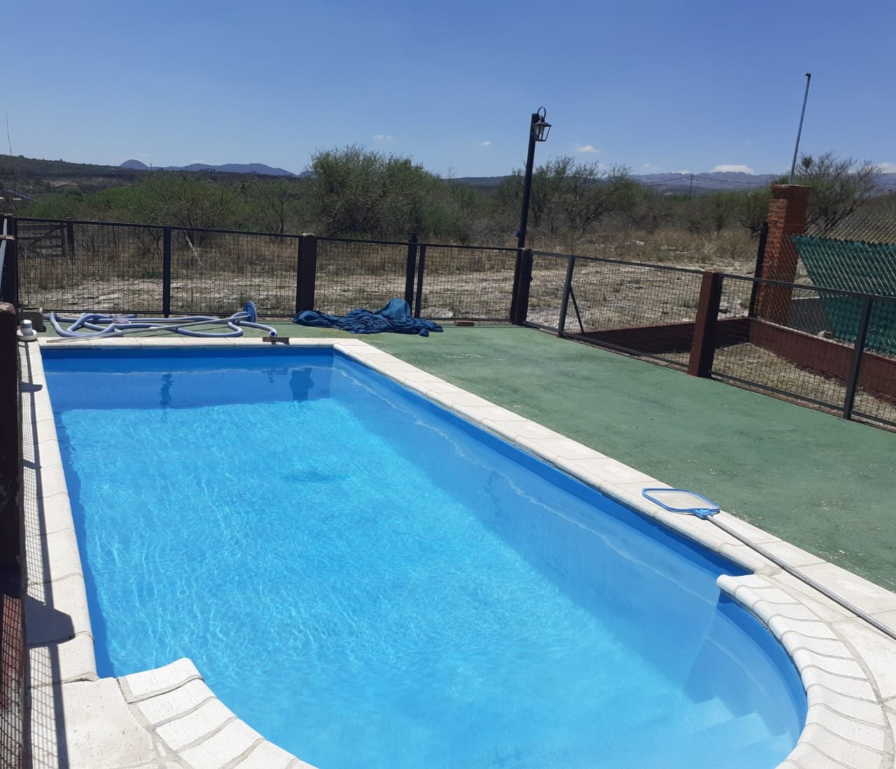 Piscina con deck amplio y vista a las sierras